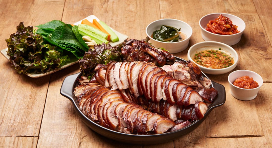 따뜻한 상 위에 올려진 족발과 보쌈 메인 이미지
